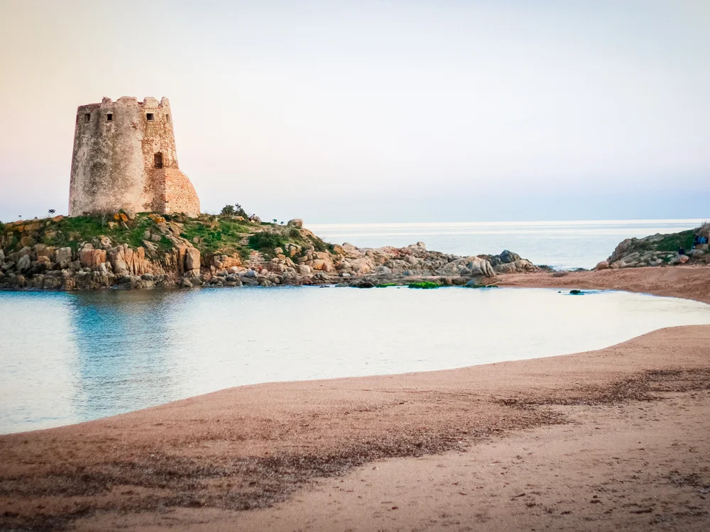 Teku Boutique Hotel a Bari Sardo – l’Ogliastra più autentica Torre di pietra su un promontorio roccioso accanto a una spiaggia e al mare
