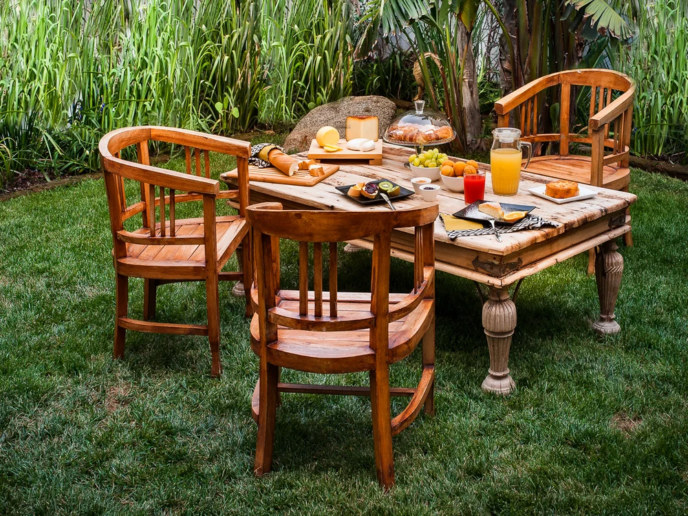 Teku Boutique Hotel a Bari Sardo – l’Ogliastra più autentica Colazione all’aperto su un tavolo di legno in un giardino verde