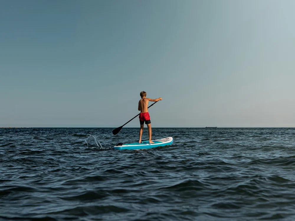 Teku Boutique Hotel a Bari Sardo – l’Ogliastra più autentica Persona in piedi su una tavola da paddle mentre rema in mare