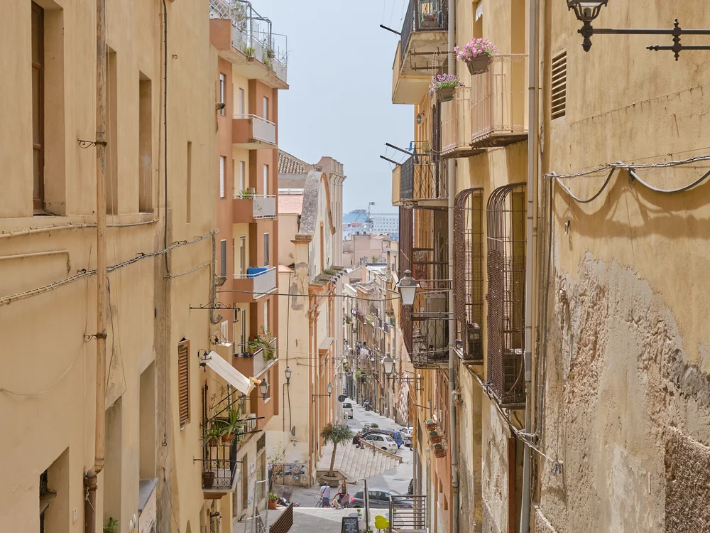 Teku Boutique Hotel a Bari Sardo – l’Ogliastra più autentica Vicolo in discesa tra edifici dai toni caldi, balconi e un lampione