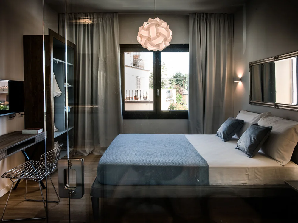 Teku Boutique Hotel a Bari Sardo – l’Ogliastra più autentica Camera da letto moderna con letto matrimoniale, scrivania e televisore